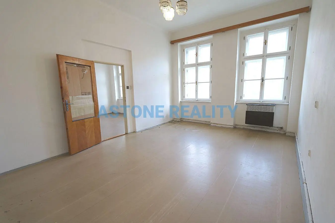 Obývací pokoj; dřevěná podlaha, přirozené světlo, moderní styl, vysoké stropy