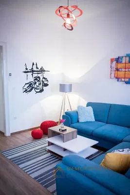 Obývací pokoj; dřevěná podlaha, přirozené světlo, moderní styl, vysoké stropy