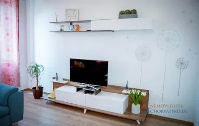 Obývací pokoj; dřevěná podlaha, přirozené světlo, moderní styl, vysoké stropy