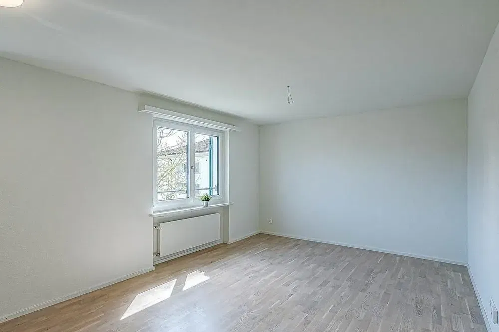 Obývací pokoj; dřevěná podlaha, přirozené světlo, moderní styl, vysoké stropy