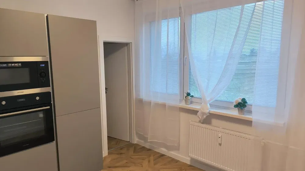 Kuchyňa; kuchynské spotrebiče, drevená podlaha, prirodzené svetlo, moderný štýl