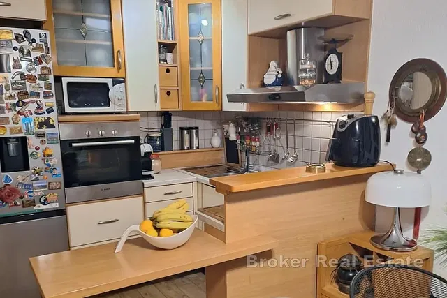 Kuchyně; kuchyňské spotřebiče, dřevěná podlaha, přirozené světlo, moderní styl