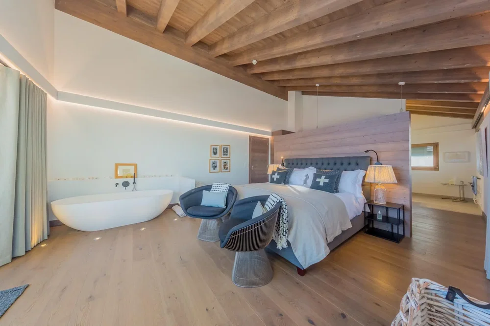 Camera da letto; travi in legno, pavimento in legno, luce naturale, stile moderno
