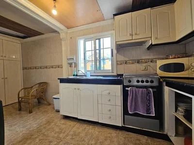 Keuken; keukenapparatuur, tegelvloer, natuurlijk licht