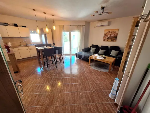 Woonkamer; tegelvloer, keukenapparatuur, natuurlijk licht