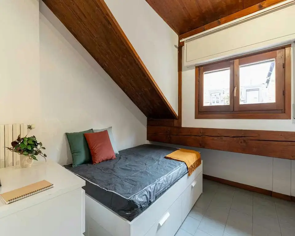 Slaapkamer; houten balken, houten vloer, tegelvloer, natuurlijk licht