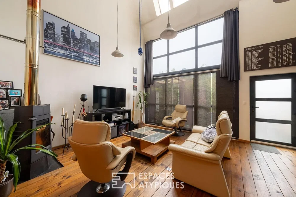 Oturma odası; şömine, ahşap zemin, yüksek tavan, doğal ışık