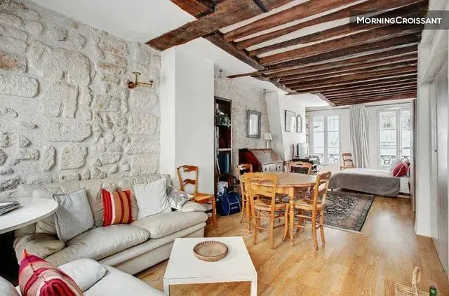 Soggiorno; travi in legno, pavimento in legno, luce naturale, stile rustico