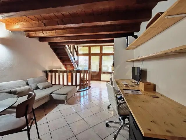 Woonkamer; houten balken, tegelvloer, natuurlijk licht, moderne stijl