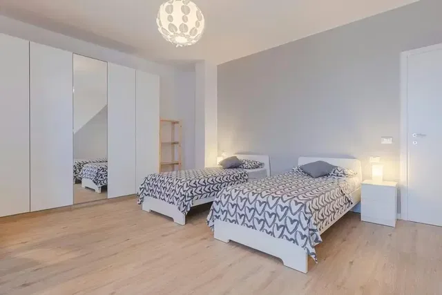 Camera da letto; pavimento in legno, luce naturale, stile moderno