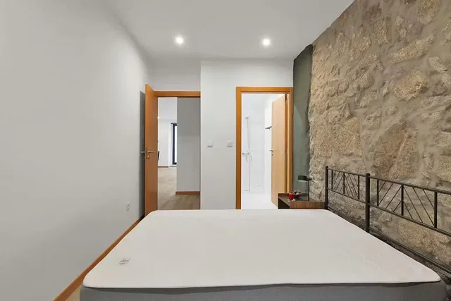 Camera da letto; luce naturale, travi in legno, stile moderno