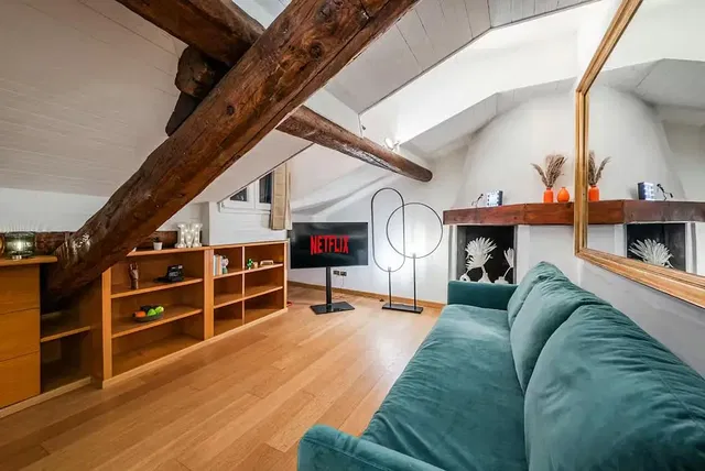 Soggiorno; travi in legno, pavimento in legno, luce naturale, stile moderno