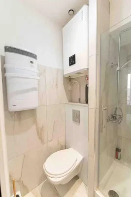 Toilettes; chauffe-eau, carrelage, lumière naturelle