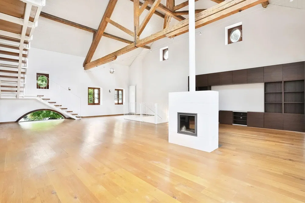Sala de estar; vigas de madeira, chão de madeira, lareira, teto alto, luz natural