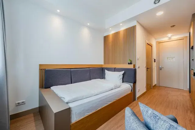 Quarto; chão de madeira, luz natural, estilo moderno