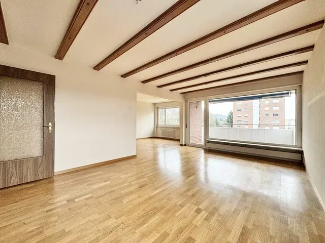 Woonkamer; houten vloer, houten balken, uitzicht, natuurlijk licht