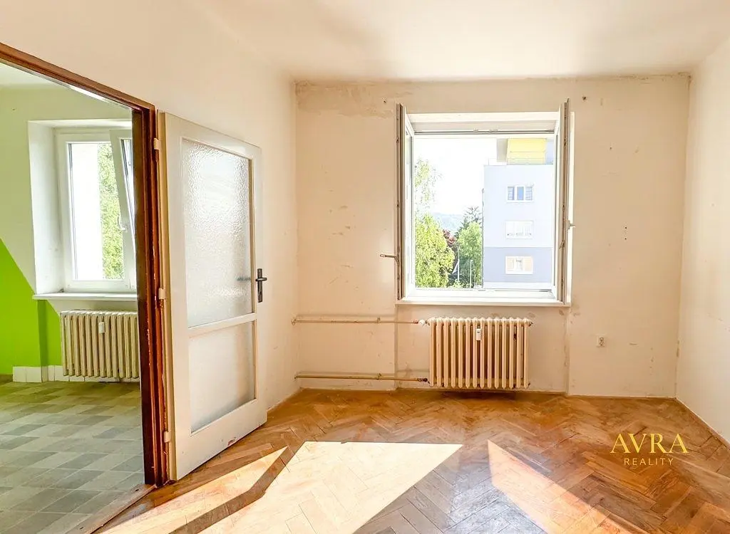 Woonkamer; renovatie nodig, houten vloer, natuurlijk licht, uitzicht
