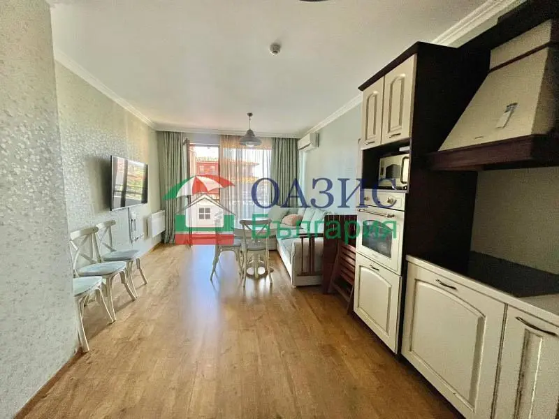 Living room; kitchen appliances, wood floor, natural light