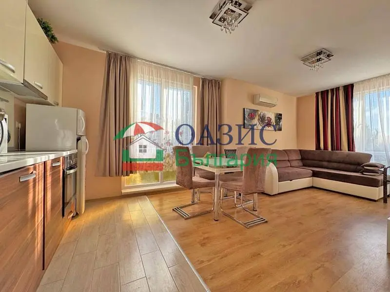 Living room; kitchen appliances, natural light, wood floor