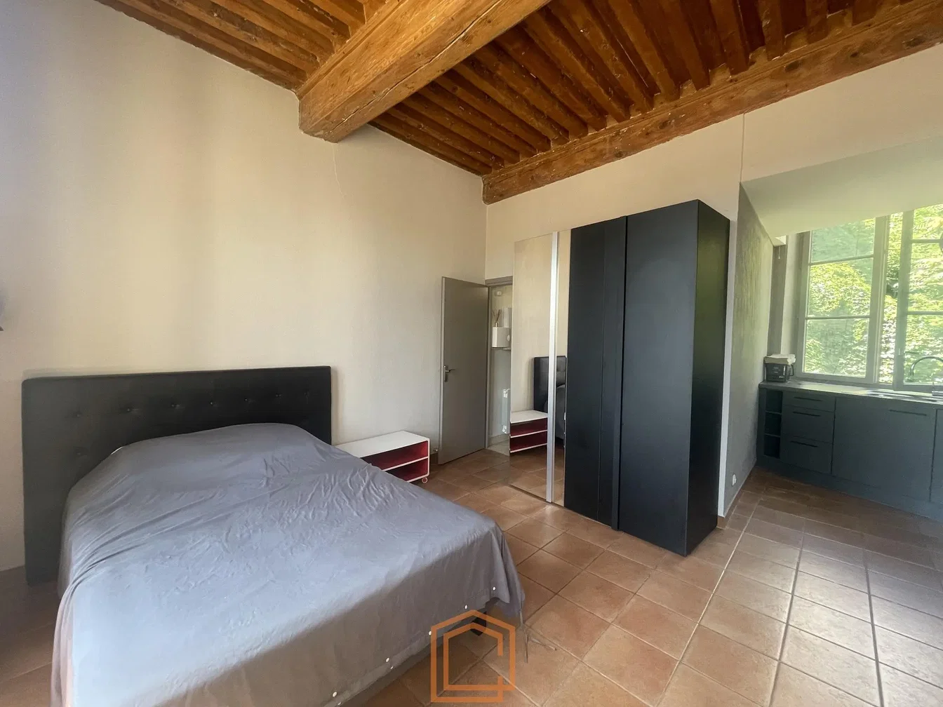 Camera da letto; travi in legno, pavimento in piastrelle, luce naturale
