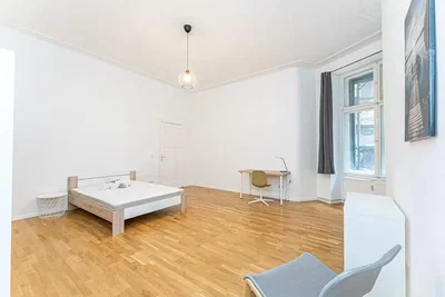 Ložnice; dřevěná podlaha, přirozené světlo
