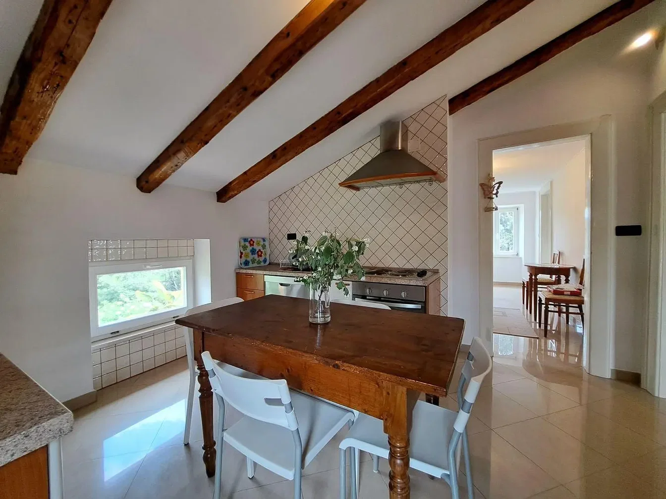 Cozinha; vigas de madeira, chão de azulejo, eletrodomésticos, luz natural