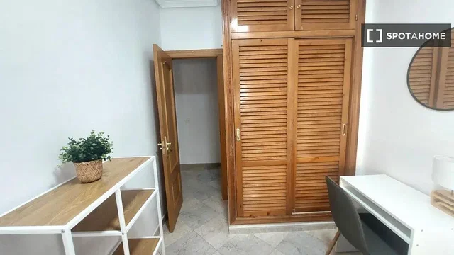 Camera da letto; pavimento in legno, travi in legno, luce naturale, stile moderno