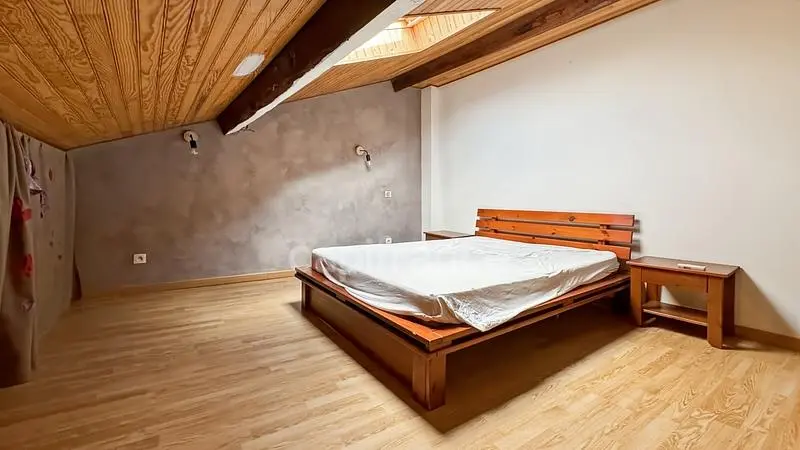 Camera da letto; pavimento in legno, travi in legno, luce naturale