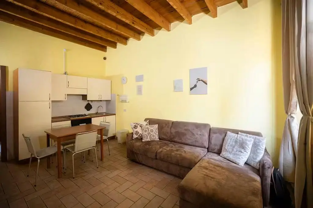 Soggiorno; travi in legno, pavimento in piastrelle, luce naturale