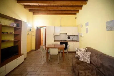 Soggiorno; travi in legno, pavimento in piastrelle, luce naturale