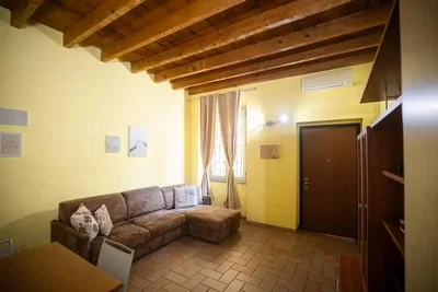 Soggiorno; travi in legno, pavimento in piastrelle, luce naturale