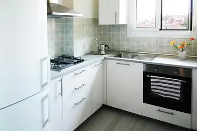 Keuken; keukenapparatuur, tegelvloer, natuurlijk licht