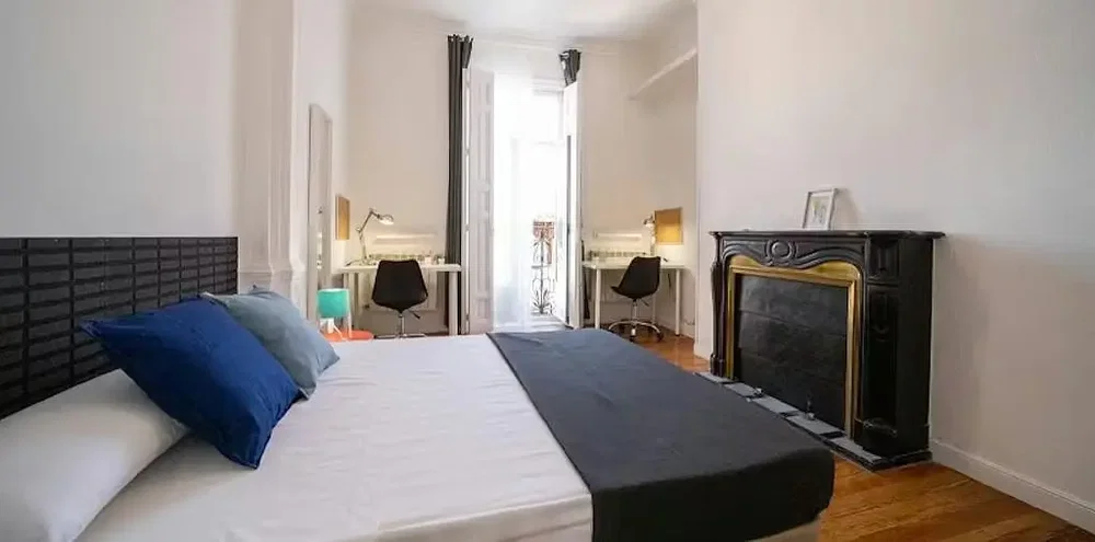 Camera da letto; pavimento in legno, camino, luce naturale