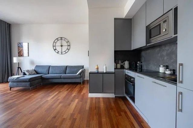 Living room; wood floor, kitchen appliances, natural light