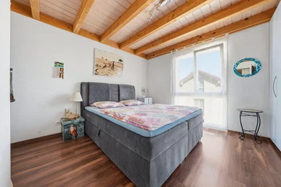 Camera da letto; travi in legno, pavimento in legno, luce naturale