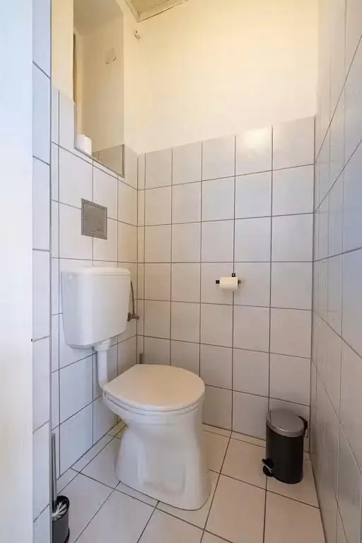 Toilet; tile floor, needs renovation