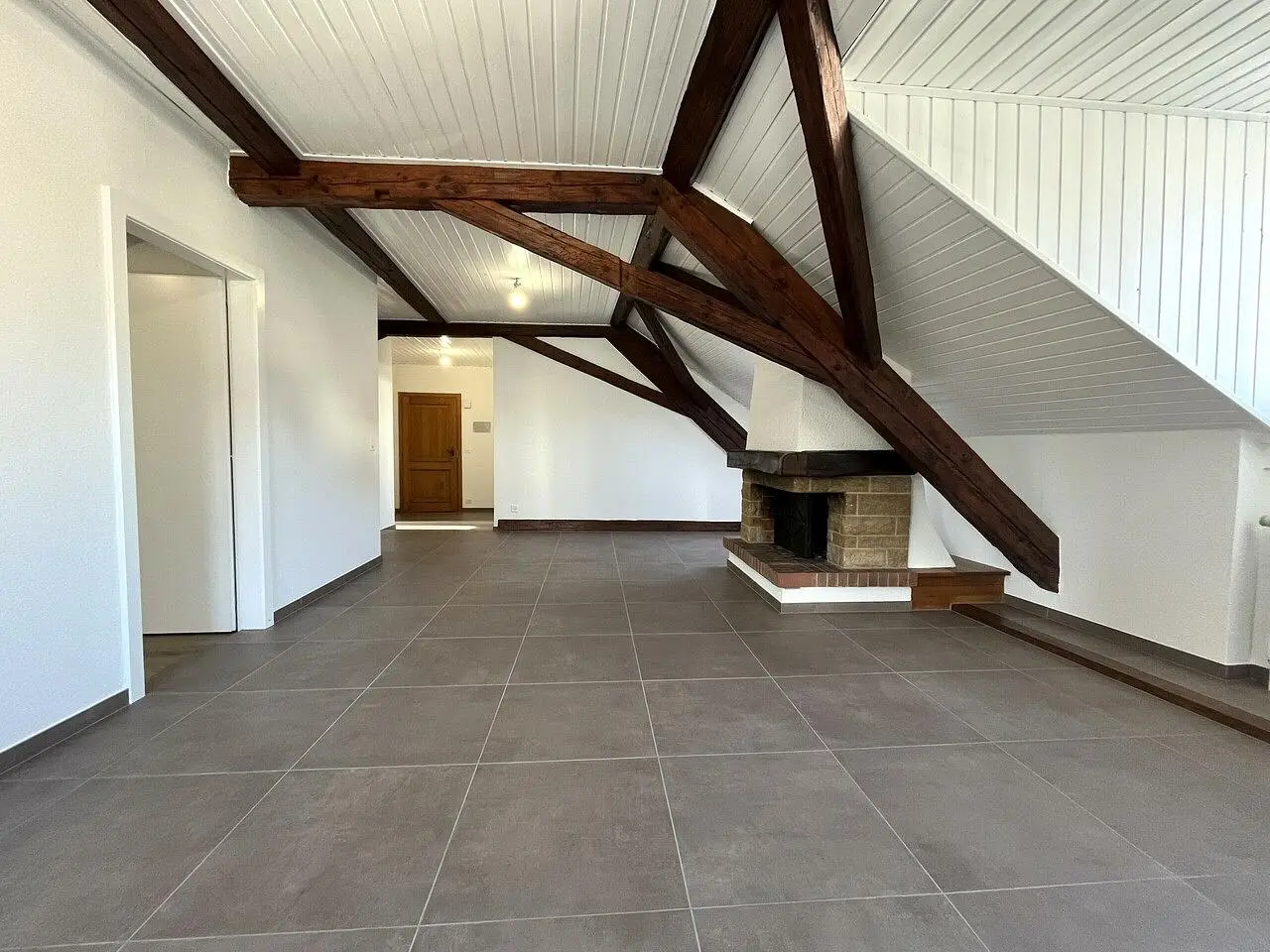 Soggiorno; travi in legno, camino, pavimento in piastrelle