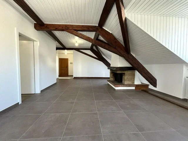 Soggiorno; travi in legno, camino, pavimento in piastrelle