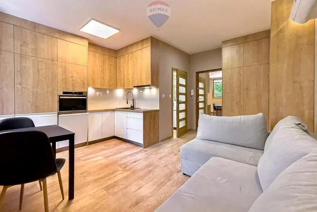 Living room; kitchen appliances, wood floor, natural light, modern style