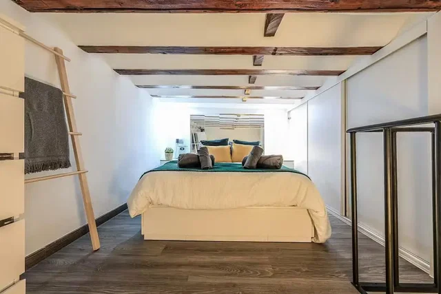 Dormitorio; vigas de madera, suelo de madera, luz natural